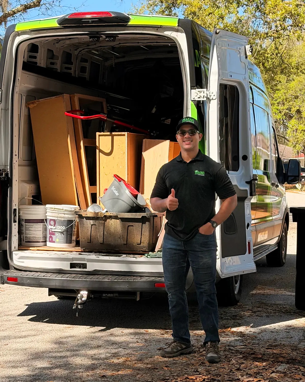 Alexander Corona, owner of MAGNO Junk Removal, in front of the company van in Davenport, FL
